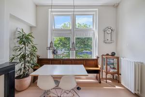 a dining room with a table and chairs and a window at In de Pastorie Utrecht - Old rectory, just steps away from the city center in Utrecht