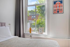 a bedroom with a bed and a window at In de Pastorie Utrecht - Old rectory, just steps away from the city center in Utrecht