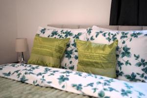 a group of pillows on a bed with at Ground Floor Flat 1 Seven Cambrian square in Newtown