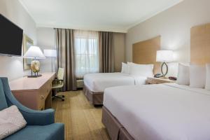 a hotel room with two beds and a chair at Holiday Inn Express Fairhope - Point Clear by IHG in Fairhope