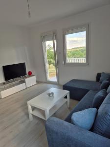 a living room with a blue couch and a white table at Pećinska Vila in Kragujevac