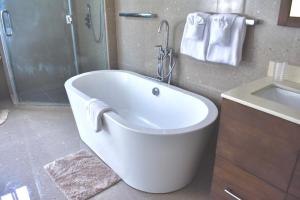 a white bath tub in a bathroom with a sink at Gold Sun Villa in Saint Annʼs Bay +6 photos