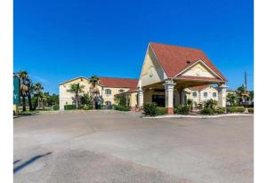 a large white building with a red roof at Studio 6 Suites Houston, TX - Spring in Houston