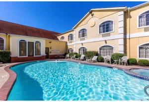 a swimming pool in front of a building at Studio 6 Suites Houston, TX - Spring in Houston