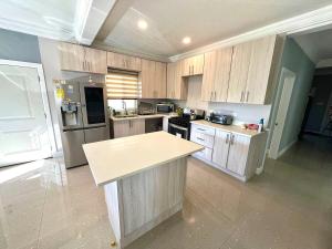a kitchen with wooden cabinets and a counter top at Gold Sun Villa in Saint Annʼs Bay
