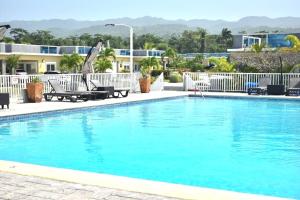 a swimming pool with blue water in a resort at Gold Sun Villa in Saint Annʼs Bay