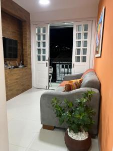a living room with a couch and a television at Aconchego do Caquende in Cachoeira