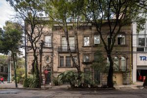 an old brick building with trees in front of it at Hotel Casa Bosques Pensión in Mexico City