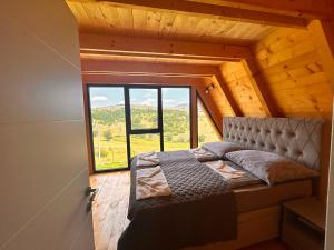 a bed in a room with a large window at Stress Away in Zlatibor