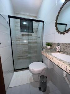 a bathroom with a toilet and a sink and a mirror at Aconchego do Caquende in Cachoeira +7 photos