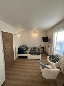 a bedroom with a bed and a couch and a chair at Le Charles Quint in Gray