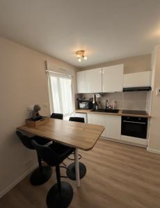 a kitchen with a wooden table and chairs in a room at Le Charles Quint in Gray