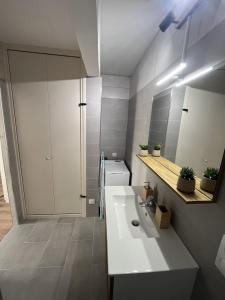 a bathroom with a white sink and a mirror at Le Charles Quint in Gray