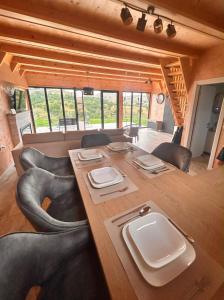a dining room with a long wooden table and black chairs at Stress Away in Zlatibor