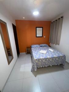 a bedroom with a bed in a room with orange walls at Aconchego do Caquende in Cachoeira