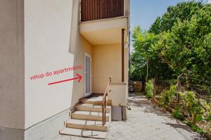 a door with a red arrow pointing to a building at Marilyn Apartment in Nitra