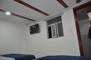 a room with a bed and a tv on the wall at Hotel Hostal Urban18 in Bogotá