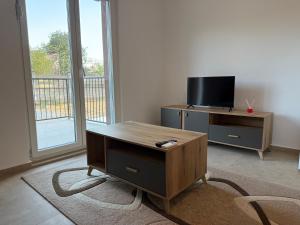a living room with a tv and a desk with a table at Comfort Residence in Tuzi