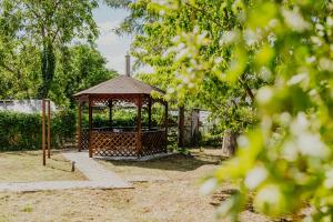 a wooden gazebo in a yard with trees at Marilyn Apartment in Nitra