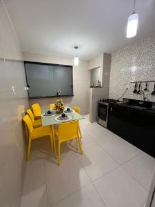 a kitchen with a table and yellow chairs in a room at Aconchego do Caquende in Cachoeira