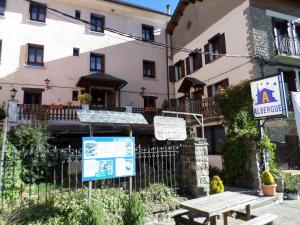 a building with a picnic table in front of it at Albergue El Último Bucardo in Linás de Broto