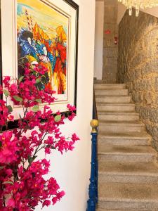 a stairway with flowers and a painting on the wall at Holzer II in Porto-Vecchio +33 photos