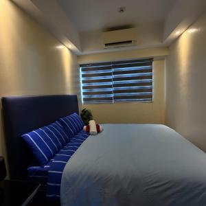 a bedroom with a large bed and a window at R2 condotel 2BR Santorini tower in Cainta