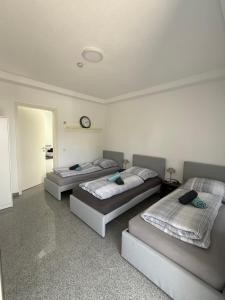 three beds in a room with a clock on the wall at Team at Home Senden W2 in Senden