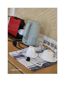 a coffee maker and cups on a table at Le MoniPol Hôtel in Franceville