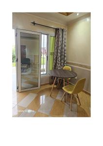 a room with a table and chairs and a glass door at Le MoniPol Hôtel in Franceville