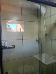 a bathroom with a glass shower with a toilet at Chalé in Jaraguá do Sul