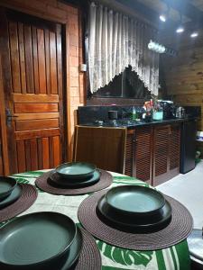 a table with black plates on top of it at Chalé in Jaraguá do Sul +9 photos