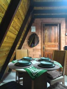 a dining room with a table with plates on it at Chalé in Jaraguá do Sul