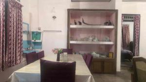a dining room with a table and a shelf with dishes at Le Stories Heritage Home in Kottayam +18 photos