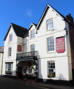 a white building with a sign on the front of it at The Lorna Doone Hotel in Porlock