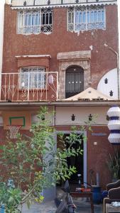 ein Backsteingebäude mit Balkon und Tisch in der Unterkunft Nasmita's in Aourir