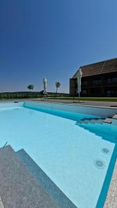 a large swimming pool with blue water in front of a building at Butični Hotel Sončno Polje in Moravske-Toplice