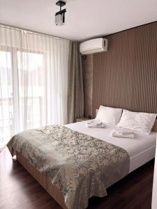 a bedroom with a large bed and a window at Clisura Dunarii - Pensiunea Casa Creta in Liborajdea