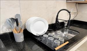 a kitchen counter with a plate and a sink at Apto 4, em Paty do Alferes in Paty do Alferes