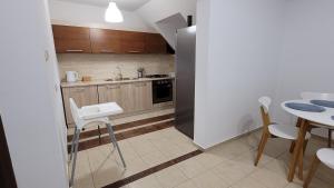 a small kitchen with a table and a refrigerator at Apartament Nad Lodziarnią in Wydminy +8 photos