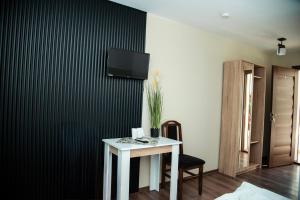 a room with a table and a tv on a wall at Clisura Dunarii - Pensiunea Casa Creta in Liborajdea