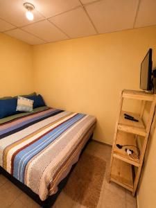 a bedroom with a bed and a tv on a shelf at Arianas Place 2 in Huehuetenango +9 photos