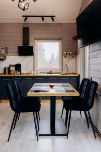 a kitchen with a table and some black chairs at Gora vitriv in Slavske