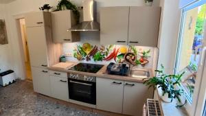 a kitchen with white cabinets and a sink at Ferienwohnung Glück auf in Gornsdorf
