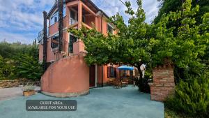 a house with a tree in front of it at Apartma Extra Virgin - Extra Virgin Apartment in Portorož