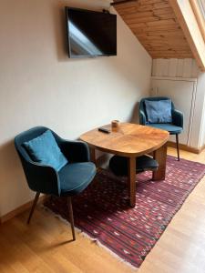 a room with a table and two chairs and a television at Villa Angela, appartement 3 chambres in Ovifat