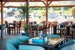 a restaurant with tables and chairs and a potted plant at Clisura Dunarii - Pensiunea Casa Creta in Liborajdea