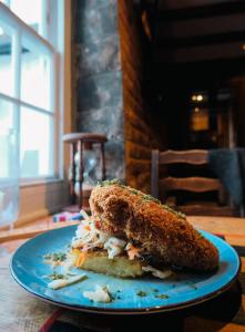 a sandwich on a blue plate on a table at The St Crispin Inn in Worth +22 photos