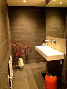 a bathroom with a sink and a vase of flowers at Naar Ineke in Doesburg