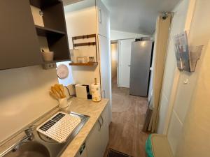 a small kitchen with a sink and a refrigerator at Mobile Home David-Camp Soline in Biograd na Moru